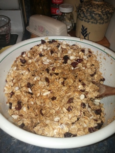 mixing roasted oats, almonds, craisins and maple syrup